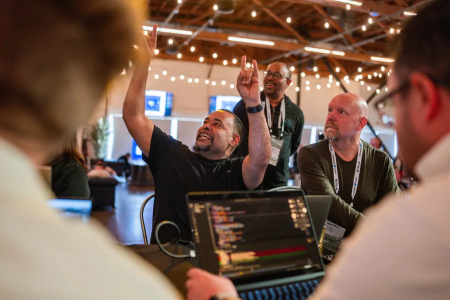 Attendees cheering at a laptop in the summit hall